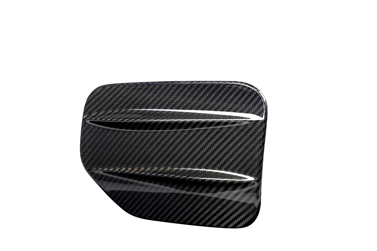 A carbon fiber automotive vent cover, angled with diagonal slats, displayed against a plain white background, emphasizing its glossy, textured surface.