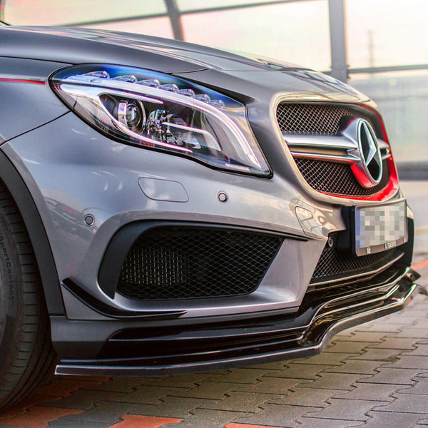 A silver car's front view parked on a tiled surface, featuring a prominent star emblem on the grille, sleek headlights, and red accents on the wheels, with glass panels in the background.