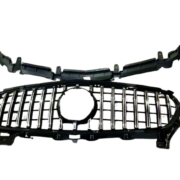 A black car grille with horizontal and vertical chrome accents lies on a white background, featuring a central circular emblem space and attached frame components.