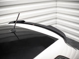 A car roof with a black roof spoiler and aerial, set in a corner with white horizontal wall panels.