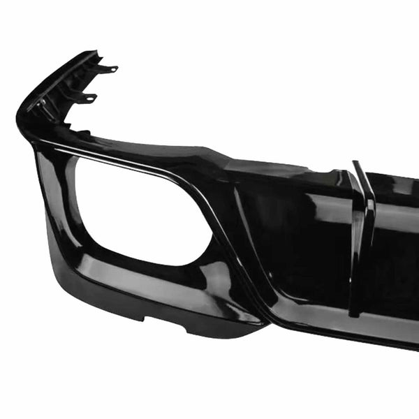 A shiny black car bumper is viewed close-up, displaying a smooth finish and angular design. It is photographed against a plain, white background, highlighting its contours.