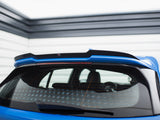 A blue car's rear window with a black spoiler is parked in a garage with horizontal wall panels. A rear wiper and an orange heating grid are visible on the window.