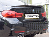 A black BMW shows its rear, featuring dual exhausts and red taillights. The license plate reads 
