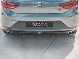 A gray car is parked with its rear bumper visible, featuring Maxton Design branding and dual exhausts. The setting is an outdoor concrete area.