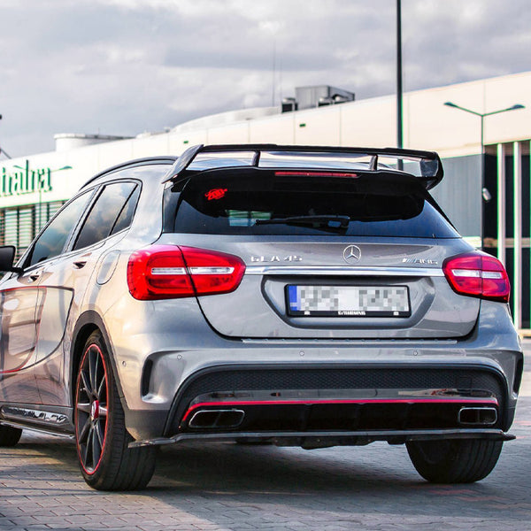 A silver car with a prominent rear spoiler is parked on a paved area. Logos read "CLA 45" and "AMG." The background features a building labeled "europa centralna."