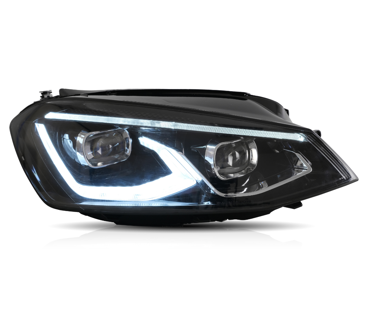 A car headlight is illuminated, showcasing its LED design with a sleek, angular shape. It is set against a plain white background, emphasizing its modern aesthetic.