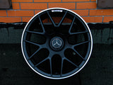 A black alloy wheel, featuring a Mercedes emblem and 