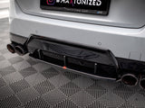 A car's rear bumper features a black diffuser and dual exhaust pipes on a patterned floor. The license plate frame reads “Dealer BMW Premium Arena Łódź.”
