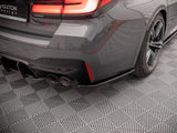 The rear of a grey car features illuminated taillights and dual exhaust pipes, stationary on a patterned floor. Visible text: 