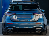 Blue Mercedes AMG A35 parked, displaying dual exhausts and a spoiler. It is situated in an industrial area, surrounded by buildings. Text on the license plate reads: 