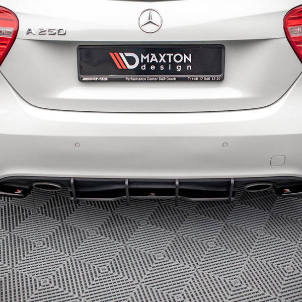 A white Mercedes A250 car is parked in a showroom on a checkered floor. The rear features a Maxton Design diffuser. The license plate reads "MAXTON design Performance Center D&R Czech T: +48 17 860 12 20."