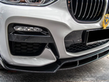 Car front bumper with a sleek design, featuring a detailed grille and a decorative emblem. The vehicle is parked on a metal-patterned surface, suggesting an outdoor or garage setting.