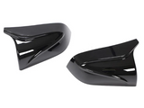 Black, glossy side mirror covers rest on a white background, angled stylishly. They feature sleek, aerodynamic curves, reflecting minimal ambient light.
