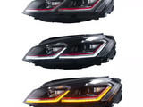 Three car headlights are aligned vertically, each with LED strips in different colors: red, white, and orange. The headlights are situated against a plain, white background.