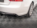 A white car's rear bumper and wheel are shown on a textured, gray, diamond-patterned floor. The car features a black diffuser underneath the bumper, adding sporty detailing.