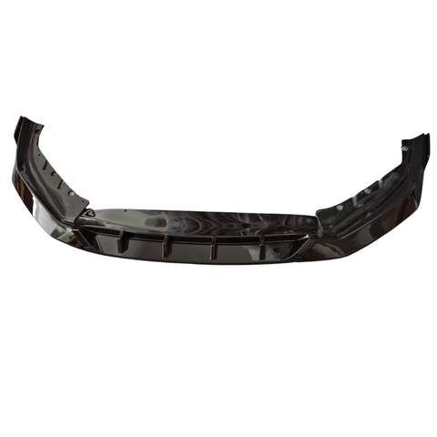 A black car bumper or front splitter, slightly curved with angular design features, is isolated against a white background. It appears shiny and reflective, with no additional elements visible.