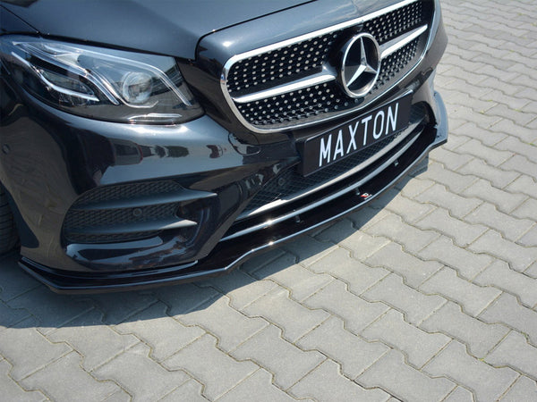 Car front with grille and headlights, parked on a paved surface. The license plate displays the text “MAXTON.”