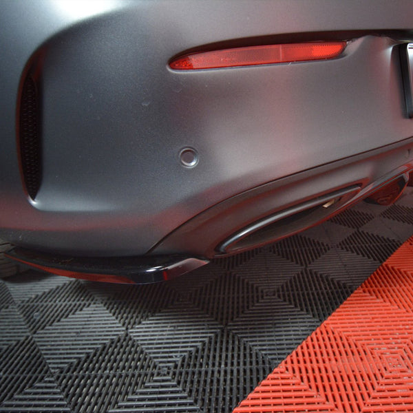 Car's rear bumper with a "MAXTON" license plate, resting on a checkered black-and-red floor.