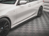 A white car with black alloy wheels is parked on a textured, patterned floor within a room with white walls.