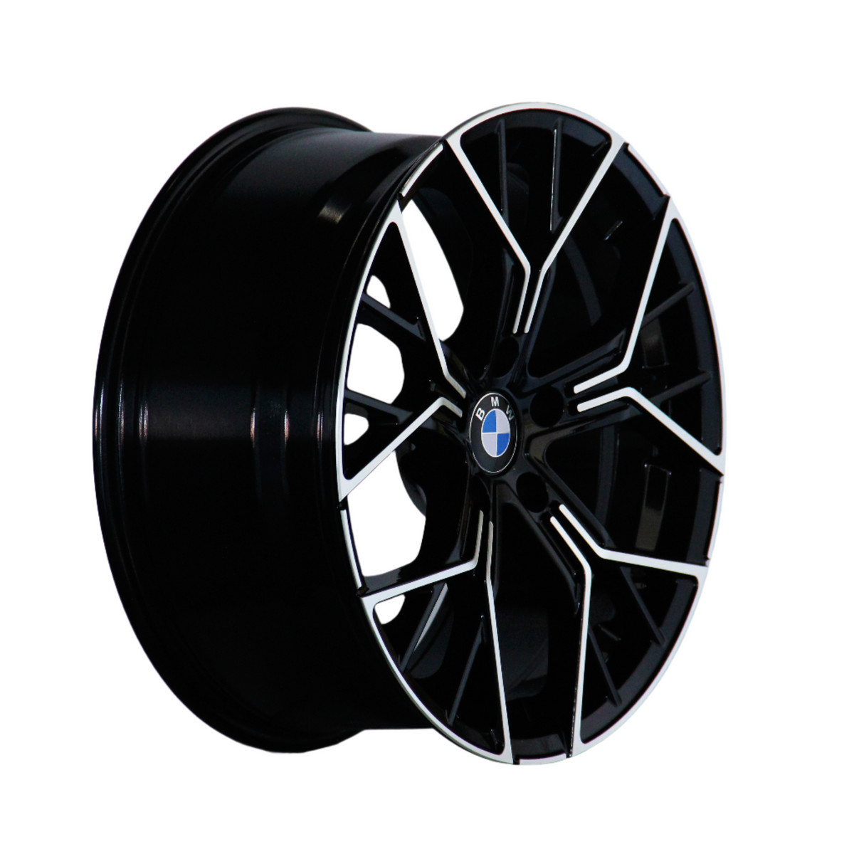 A black alloy wheel with intricate silver patterns and a BMW emblem is positioned against a white background, showcasing its glossy finish and angular design.