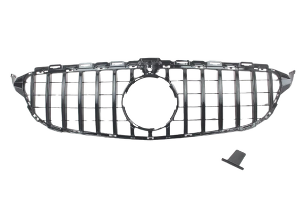 A car grille with vertical slats, designed for a front bumper, includes a circular central opening, placed on a plain white background. A small, detached piece lies nearby.
