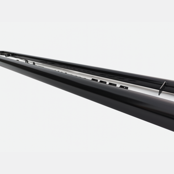 A long, black metal rail features a series of small protrusions along its surface, positioned against a plain white background, suggesting an industrial or architectural context.