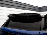A blue Range Rover parked in a garage. The vehicle's rear is in focus, showcasing tinted windows and a spoiler. The word 