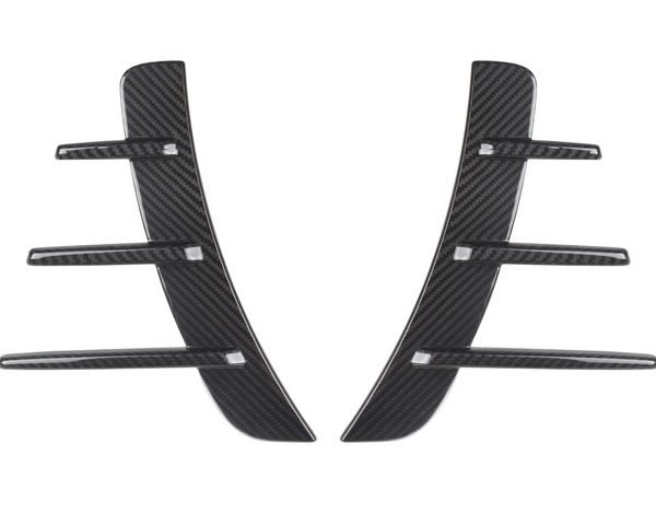 Carbon fiber car vent accents, featuring a central vertical piece with five horizontal fins, rest against a white background, showcasing their sleek and modern design.