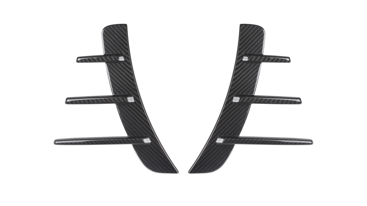 Carbon fiber car vent accents, featuring a central vertical piece with five horizontal fins, rest against a white background, showcasing their sleek and modern design.