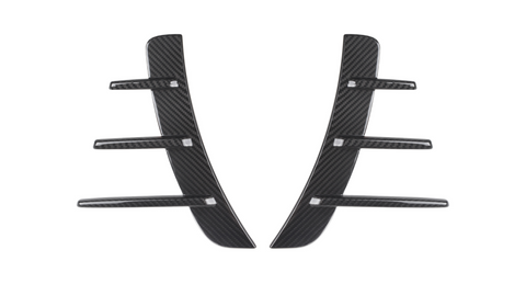 Carbon fiber car vent accents, featuring a central vertical piece with five horizontal fins, rest against a white background, showcasing their sleek and modern design.