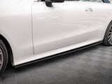 A white car parked on a patterned gray floor has visible side panels and wheels. The sleek design is highlighted by reflections on the clean surface.
