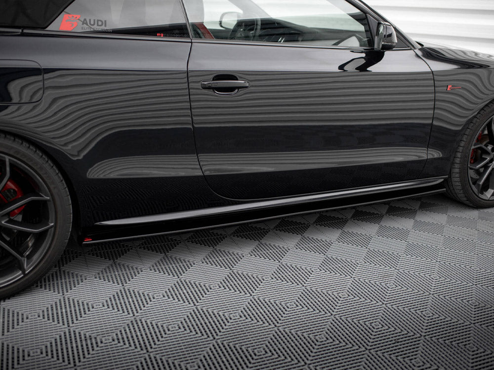 Car side with black body featuring red and black wheels, parked on a patterned floor; decals read "AUDI ELITE" and "mygermansports.com" on the window.