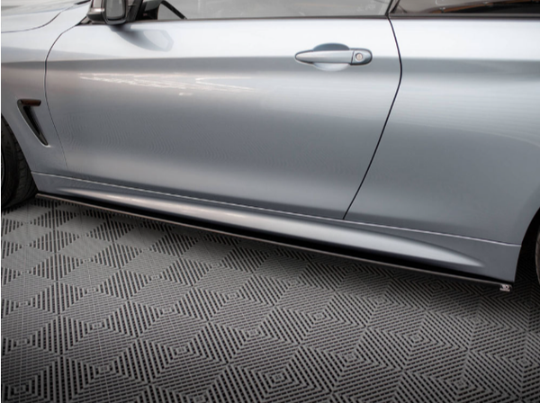 A silver car's side view, featuring a closed door and visible handle, rests on a textured, patterned floor.