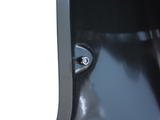 A shiny, black surface with a small, silver button or screw is attached in its center, resting in a smooth, reflective environment.