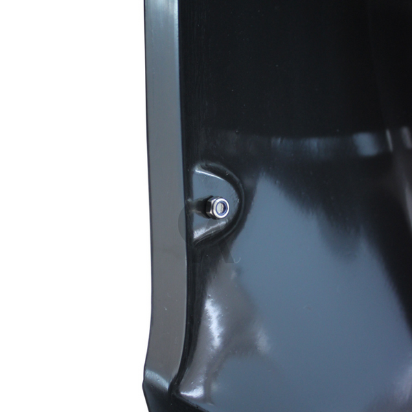 A shiny, black surface with a small, silver button or screw is attached in its center, resting in a smooth, reflective environment.