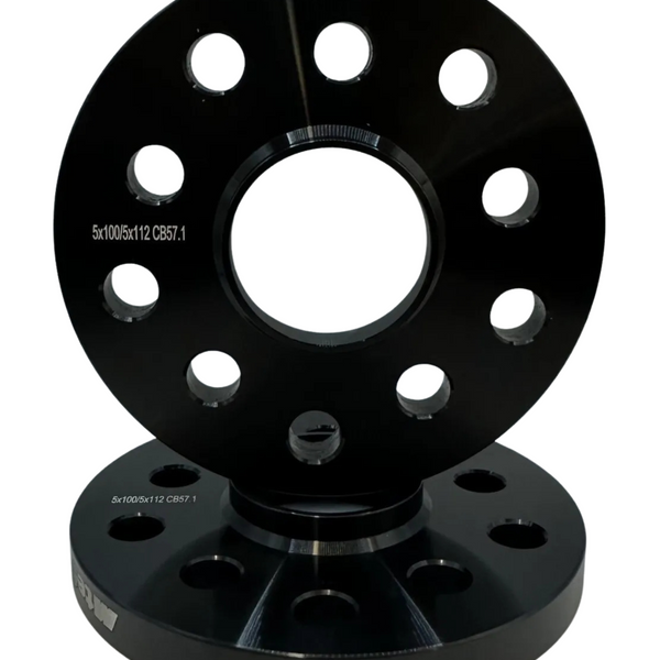 Two black, circular metal wheel spacers with multiple evenly spaced holes, stacked vertically. Text reads “5x100/5x112 CB57.1.” The background is plain white, emphasizing the products.