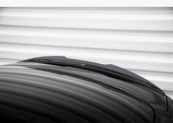 A glossy black car roof appears in front of horizontally striped, blurred white background, with a subtle structure and a small detail on top.