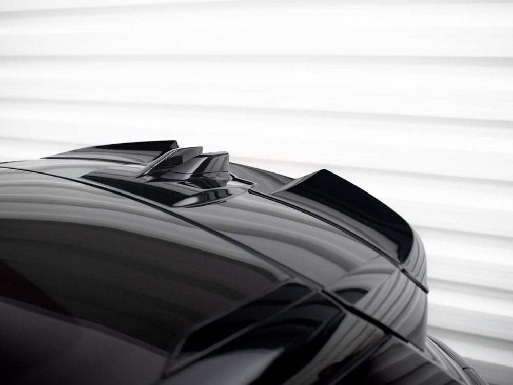 A reflective black car roof features dual roof fins, set against a softly lit, horizontal white background, emphasizing sleek design and modernity.