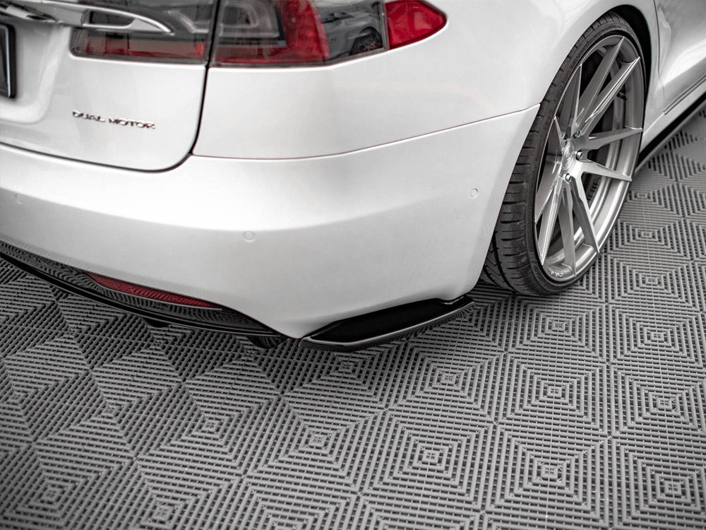 Car rear view showcases a silver vehicle with the text "D U A L M O T O R," parked on a patterned, gray floor featuring diamond designs. Subtle reflections highlight the polished surface.