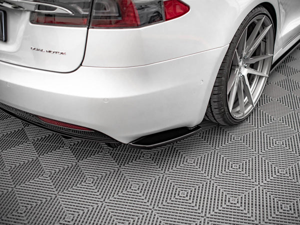 Car rear view showcases a silver vehicle with the text "D U A L M O T O R," parked on a patterned, gray floor featuring diamond designs. Subtle reflections highlight the polished surface.