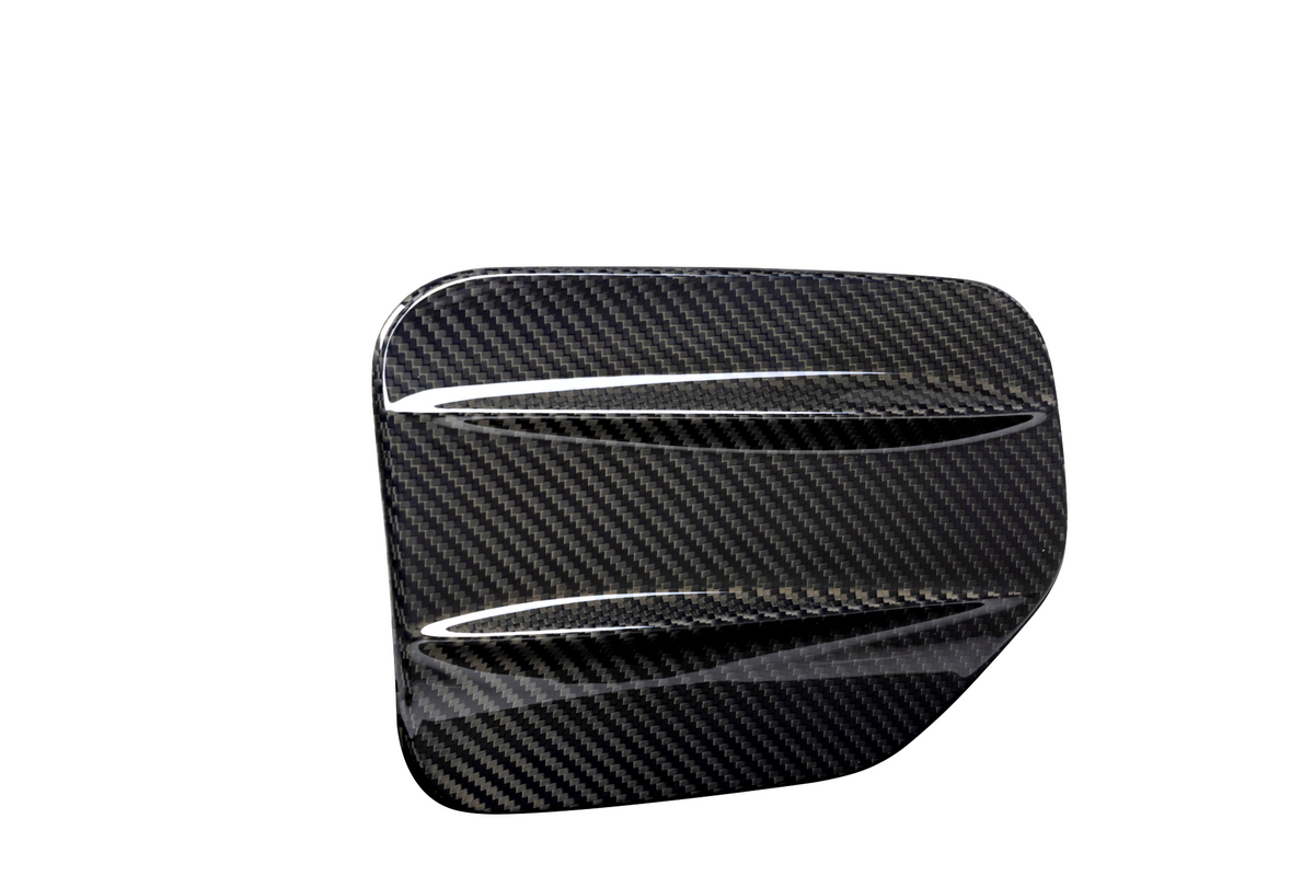 A sleek, carbon fiber car accessory with two aerodynamic ridges, set against a plain white background, showcasing its glossy textured pattern.