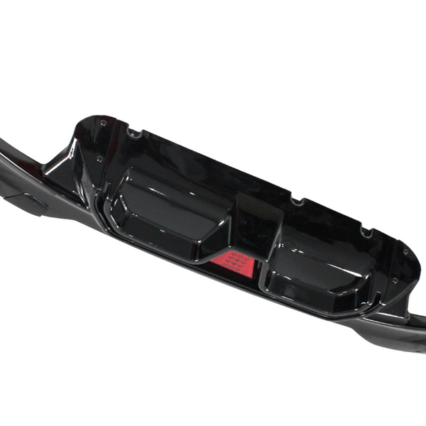 A glossy black car bumper with aerodynamic contours and a central red reflector, displayed against a white background.