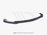 A black aerodynamic car component, resembling a front splitter, rests on a plain white background. Text below reads: 