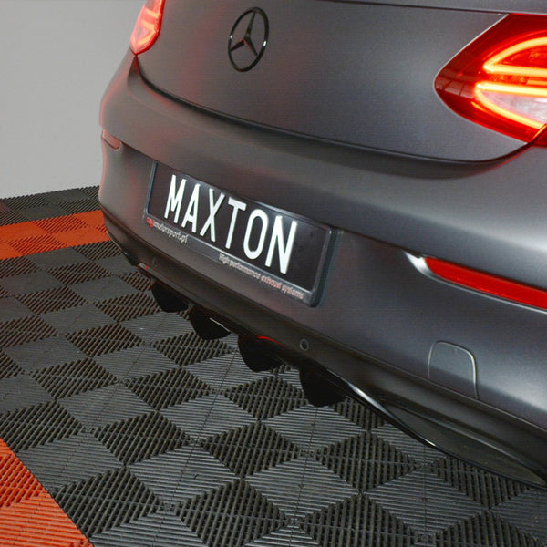 A rear view of a car with illuminated tail lights is parked on a checkered floor. The license plate reads "MAXTON." The floor has red and black tiles.