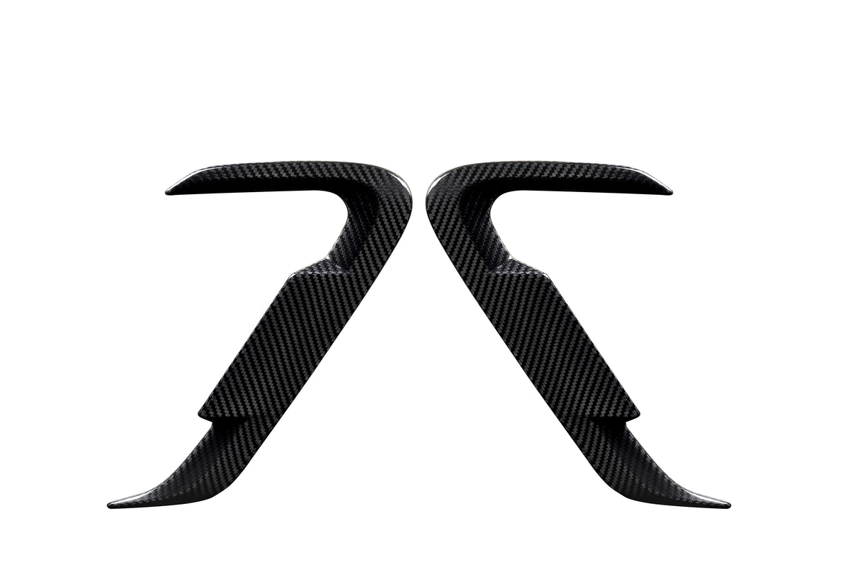 Two carbon fiber car door handles positioned symmetrically, facing each other against a white background, showcasing their sleek, contoured design and smooth texture.