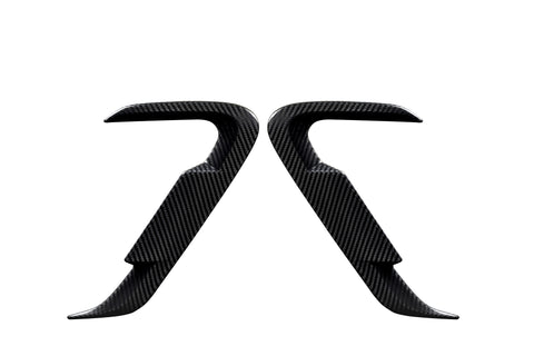 Two carbon fiber car door handles positioned symmetrically, facing each other against a white background, showcasing their sleek, contoured design and smooth texture.