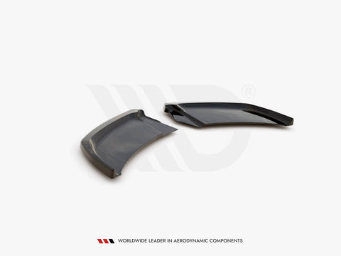 Two sleek, aerodynamic black plastic components rest on a white surface, angled adjacent to each other. Text below reads: "WORLDWIDE LEADER IN AERODYNAMIC COMPONENTS."
