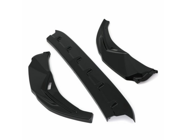 Three black car parts, possibly aerodynamic components, are arranged on a white background. Two pieces are angled with a geometric design, and one is a straight, ribbed section.