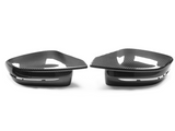 Two carbon fiber car mirror covers rest side by side on a white surface, showcasing their sleek, aerodynamic design and glossy finish.
