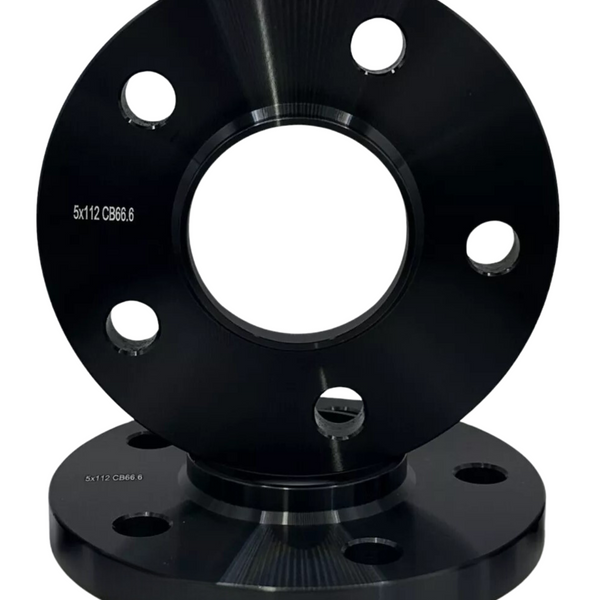 A black metal wheel spacer with circular holes is stacked upright on another. Both have the text "5x112 CB66.6" engraved on them, against a plain white background.